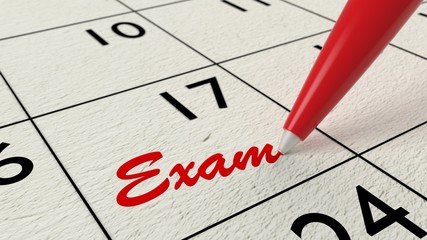 Exam reminder in calendar closeup with pen