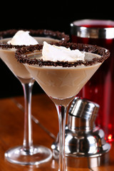 Chocolate martini garnished with chocolate powder and sprinkles on the rim and whip cream