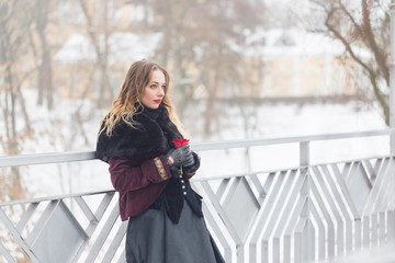 beautiful girl standing on the pedestrian bridge in winter