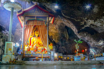 Obraz premium Light from the outside. Buddha inside the cave to the top of the mountain.