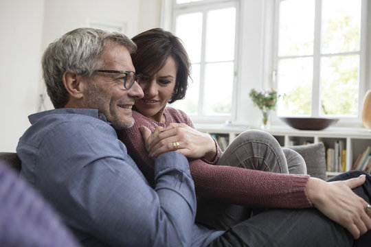 Smiling mature couple at home on the sofa