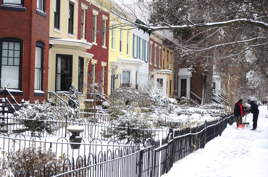 Brightly painted old town houses add color to a snow covered street in Washington DC