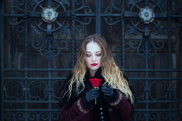 Fototapeta premium a beautiful girl standing at the lattice wrought