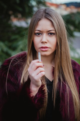 Naklejka premium Pretty girl smoking in the park