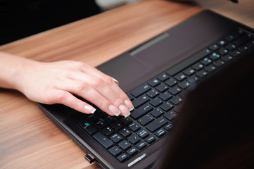 Closeup of hands of beautiful business woman working with comput