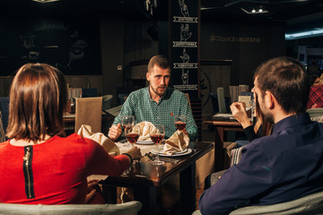 Two Couples Enjoying Meal In Restaurant Together