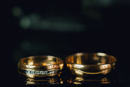 Fototapeta Beautiful wedding golden rings on dark background