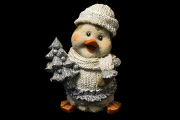Obraz premium cute ceramic figure of penguin in knitted clothes with small pine tree, cristmas toy on black background