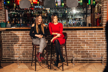 Obraz na płótnie Canvas two women sitting at the bar,have fun smile