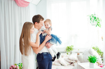 Lovely family smiling and laughing, posing at camera, and huggin