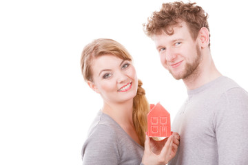 Cheerful young couple with house model.