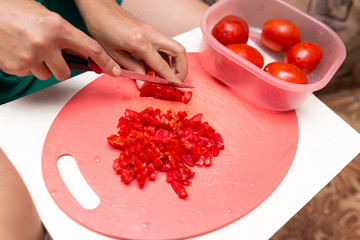 girl cuts a tomato knife