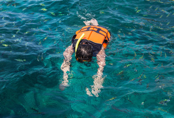 the man snorkeling with life jackets in andaman sea at phi phi islands, Thailand