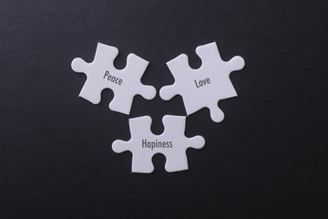 White puzzle on black background with Love Peace Hapiness Word.