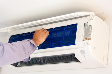 specialist cleans and repairs the wall air conditioner