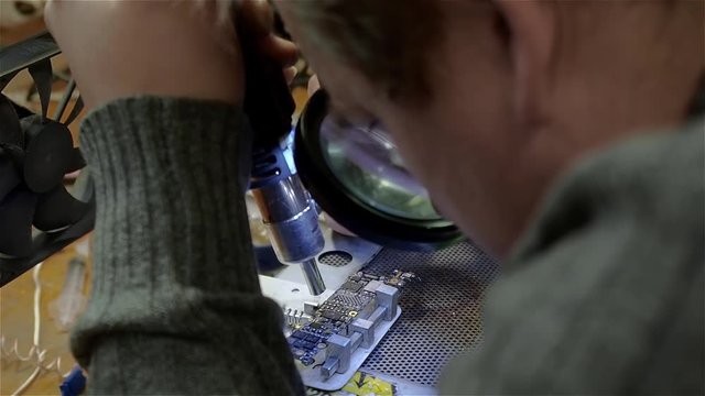 Engineer preparing motherboard of smartphone iphone to repair
