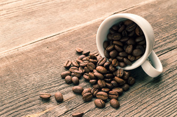 Cup full of coffee beans on the wooden table