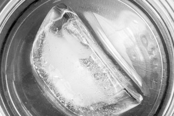 Closeup of ice cube in glass viewed from above, black and white