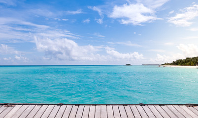 Wooden floor with sea and blue sky background.