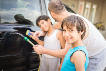 Young father and little sons washing ca