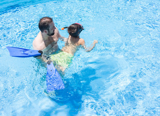 Dad teaching kid to swim