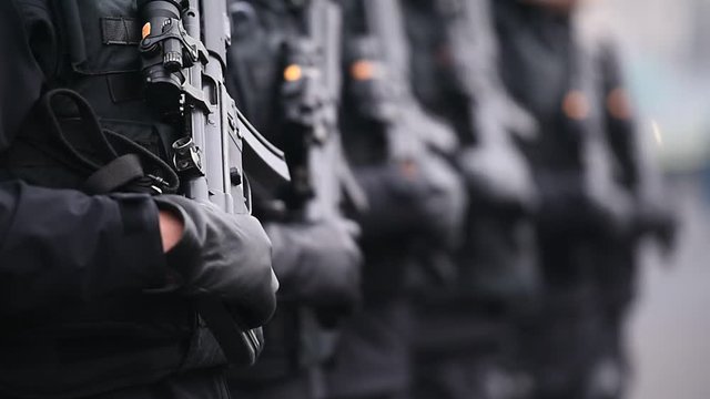 Soldier hand in black glove holding automatic machine gun during a military parade