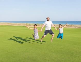 Happy children on summer gulf grass terrain having fun and happy