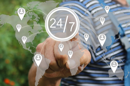 Farmer businessman clicks on the button 24 hours 7 days web service icon on a virtual screen . Tanned hands, male hands of an elderly person .  