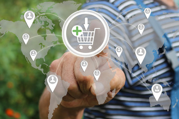 Farmer businessman  clicks on the shopping cart web on the touch screen the web network .The concept of online auctions. Tanned hands, male hands of an elderly person .