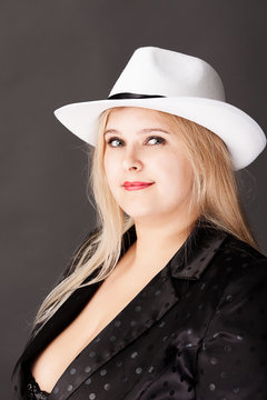 Beautiful fat woman with big breasts in a jacket and hat. Deep neckline.  Overweight. Stock Photo