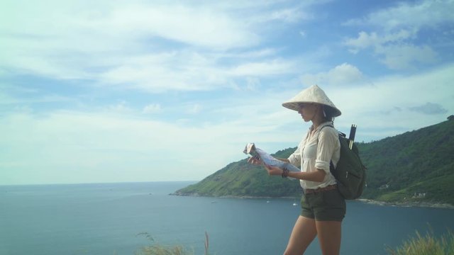 Female Tourist Reading Map At The Top Of The Hill