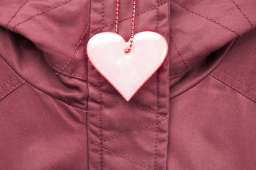 Cute rose safety reflector in the form of heart on the winter jacket. Necessary equipment to...