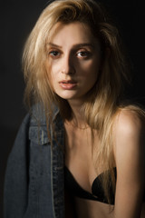 Fototapeta premium Portrait of sad beautiful young blonde woman in bra and jeans jacket