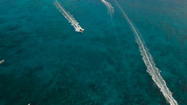 Aerial view of speed boat in sea. Speed boat at sea, view from above. Aerial video of speedboat floating in a turquoise blue sea water. Motorboat crossing ocean. Tropical landscape. Philippines