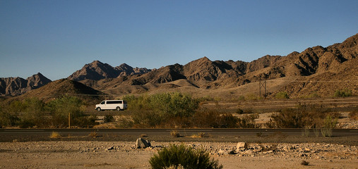 Lone Desert Highway/Van on alonely stretch of highway in the Mojave Desert, Califirnia.