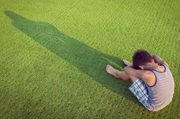 Sad lonely kid on green meadow
