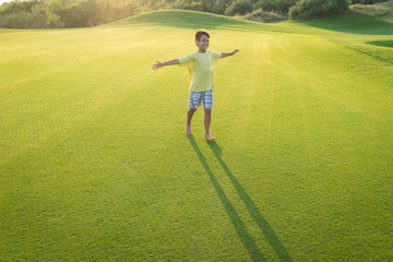 Kids on beautiful green meadow with long shadows