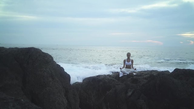 Young Woman Doing Yoga On Coast Of Sea