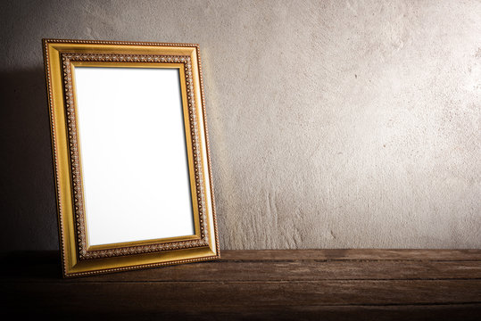 luxurious photo frame on wooden table over grunge background