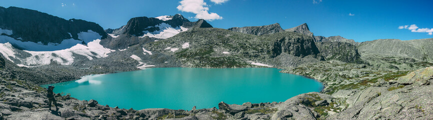 Photographer takes picture of matte cyan Strong Lake at an altitude