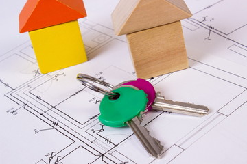 Houses of wooden blocks and keys on construction drawing of house, building house concept