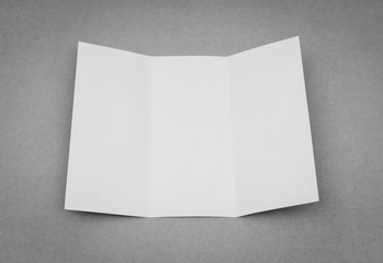 Trifold white template paper on gray background .