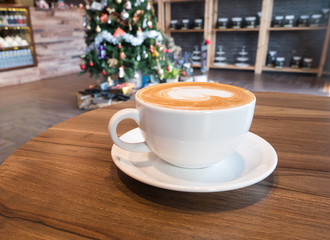 Delicious hot coffee in white cup on wooden table