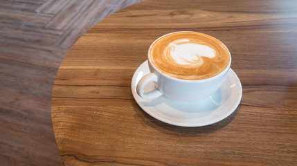 Delicious hot coffee in white cup on wooden table
