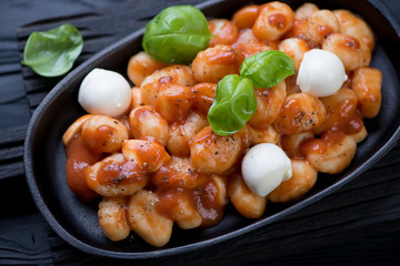 Closeup of potato gnocchi with tomato sauce and mozzarella