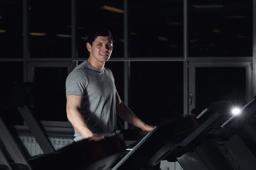 Fototapeta na wymiar man smiling at the gym doing exercise on the treadmill.