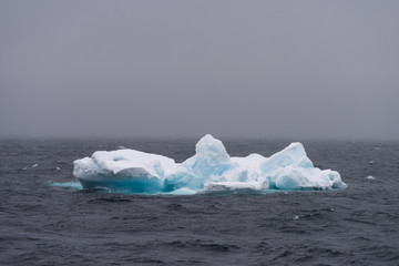 Alone iceberg floating in water