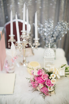 pink bouquet on white dinner table set with cancle