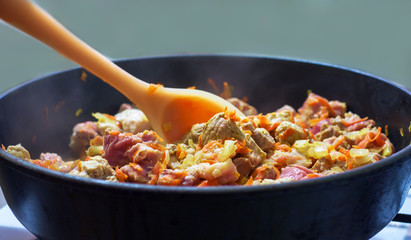 meat with onion and carrot fried in a pan