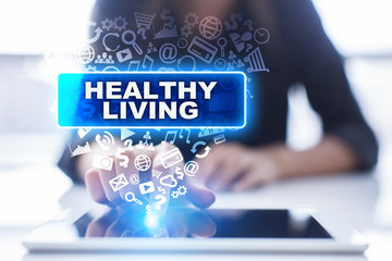 Woman is using tablet pc, pressing on virtual screen and selecting healthy living.